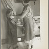 Mrs. Rustan combing her young son's hair. Rustan brothers' farm, Dickens, Iowa. Note running water