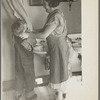 Mrs. Rustan combing her young son's hair. Rustan brothers' farm, Dickens, Iowa. Note running water