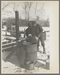 Farmers preparing "warm drink" for their hogs. Temperature: 15 below zero. Rustan Brothers farm near Dickens, Iowa, owned by Metropolitan Life Insurance Company. This farm was formerly owned by Rustan's father-in-law who built all the buildings