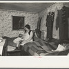 Mother and child in crowded bedroom of home of L.H. Nissen, hired man. He is married, has seven children, one grandchild, all living together in three rooms