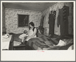 Mother and child in crowded bedroom of home of L.H. Nissen, hired man. He is married, has seven children, one grandchild, all living together in three rooms