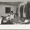 Mother and child in crowded bedroom of home of L.H. Nissen, hired man. He is married, has seven children, one grandchild, all living together in three rooms