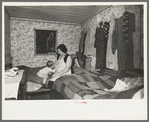 Mother and child in crowded bedroom of home of L.H. Nissen, hired man. He is married, has seven children, one grandchild, all living together in three rooms