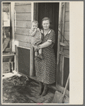 Mrs. Paul Rauhauser and one of her seven children in their home at Ruthven, Iowa