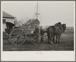 6:15 a.m. After hitching his horses to the oat seeder, Tip Estes prepares to go out in the fields, Fowler, Indiana