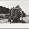 Southeast Missouri Farms Project. Transportation; privies being loaded onto truck. Wood cribbing is for privy well