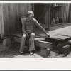 Farmer sitting on rotted porch of his old home, Southeast Missouri farms