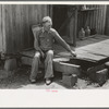 Farmer sitting on rotted porch of his old home, Southeast Missouri farms