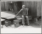 Farmer sitting on rotted porch of his old home, Southeast Missouri farms