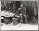 Farmer sitting on rotted porch of his old home, Southeast Missouri farms