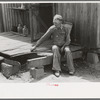 Farmer sitting on rotted porch of his old home, Southeast Missouri farms
