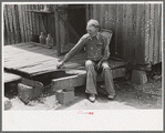 Farmer sitting on rotted porch of his old home, Southeast Missouri farms