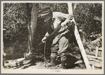 William Besson removing the iron pipe drill from casing near Winton, Minnesota