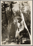 William Besson shaking his iron drill to dislodge particles of structure from the bottom of it near Winton, Minnesota