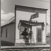 Girl washing windows of cafe, Cook, Minnesota