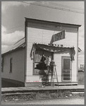 Girl washing windows of cafe, Cook, Minnesota