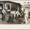 Men taking bed apart at S.W. Sparlin auction sale, Orth, Minnesota