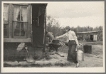 Daughter of cut-over farmer carrying water near Northome, Minnesota