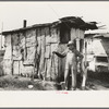 Resident of "Tin Town" on river side of levee, Caruthersville, Missouri, in front of one of his two shacks