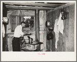 Squatter makes coffee in kitchen at his home in abandoned warehouse, Caruthersville, Missouri