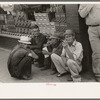 Farmers squatting on sidewalk, Caruthersville, Missouri