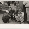 Farmers squatting on sidewalk, Caruthersville, Missouri