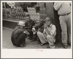 Farmers squatting on sidewalk, Caruthersville, Missouri