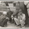 Farmers squatting on sidewalk, Caruthersville, Missouri