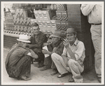 Farmers squatting on sidewalk, Caruthersville, Missouri