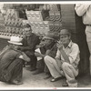 Farmers squatting on sidewalk, Caruthersville, Missouri