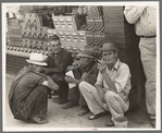 Farmers squatting on sidewalk, Caruthersville, Missouri