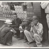 Farmers squatting on sidewalk, Caruthersville, Missouri