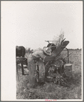 Member of Lake Dick Cooperative Association repairing mowing machine, Arkansas