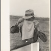 Farmer adjusting mask to avoid dust in haying operations. Lake Dick Project, Arkansas