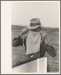 Farmer adjusting mask to avoid dust in haying operations. Lake Dick Project, Arkansas