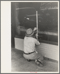 Window sign painter preparing to apply letters, Crowley, Louisiana