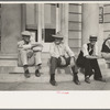 Men sitting on bank steps during National Rice Festival, Crowley, Louisiana