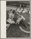People resting on grass plot in middle of street, National Rice Festival, Crowley, Louisiana