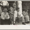 People sitting on sidewalk waiting for parade, National Rice Festival, Crowley, Louisiana