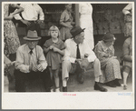 People sitting on sidewalk waiting for parade, National Rice Festival, Crowley, Louisiana