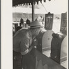 Man looking through penny peep show, state fair, Donaldsonville, Louisiana