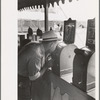 Man looking through penny peep show, state fair, Donaldsonville, Louisiana