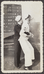 Photograph of sailors embracing on rooftop