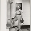 Joseph La Blanc, wealthy Cajun farmer, standing on steps of home with birds from a morning shooting, Crowley, Louisiana