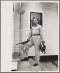 Joseph La Blanc, wealthy Cajun farmer, standing on steps of home with birds from a morning shooting, Crowley, Louisiana