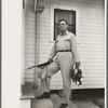 Joseph La Blanc, wealthy Cajun farmer, standing on steps of home with birds from a morning shooting, Crowley, Louisiana