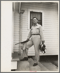 Joseph La Blanc, wealthy Cajun farmer, standing on steps of home with birds from a morning shooting, Crowley, Louisiana