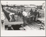 Negro stevedores loading stove on boat, Burrwood, Louisiana