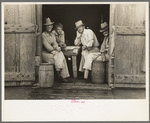 Group of men in a shack on the levee near Norco, Louisiana. They were taking refuge from the rain