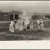 Group of women working along railroad tracks hoeing and burning cut grass, Picayune, Mississippi